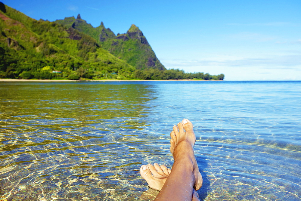 Bare Feet In The Clear Shallow Water Along The Coast Of An Hawaiian Island, Kauai, Hawaii, United States Of America