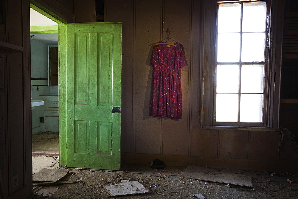 Room Inside An Old Abandoned House With A Green Door Open And An Old Dress Hanging On The Wall, United States Of America