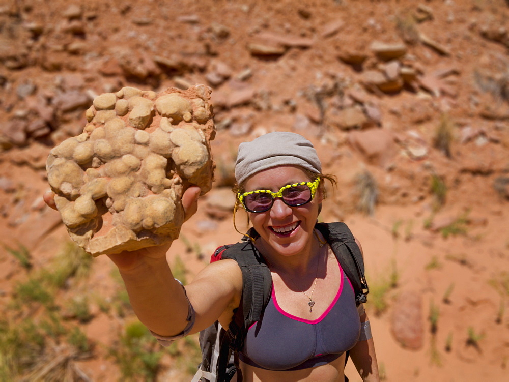 Female Adventurer With A Desert Rock Sample, Hanksville, Utah, United States Of America