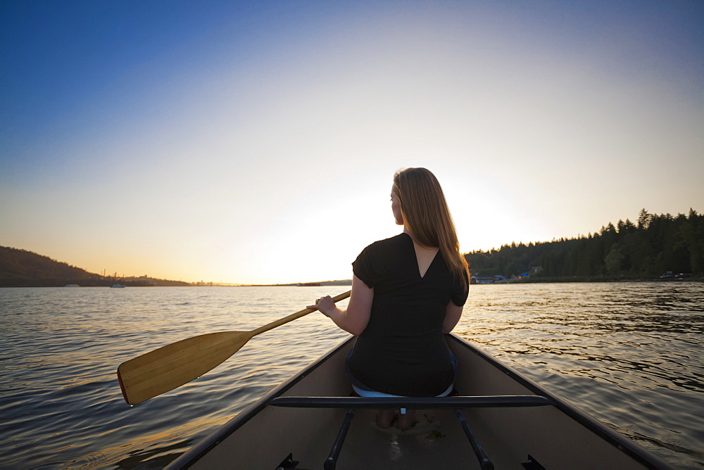 A Young Woman Canoeing At Sunset, Vancouver, British Columbia, Canada