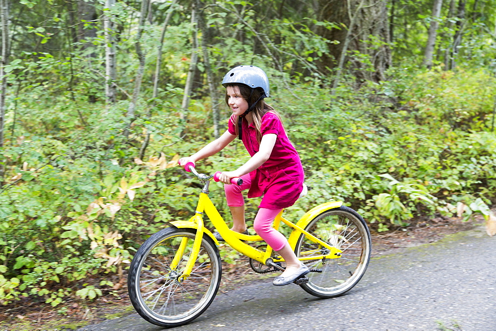 A Young Girl Rides Her Yellow Bicycle On A Trail, Salmon Arm, British Columbia, Canada