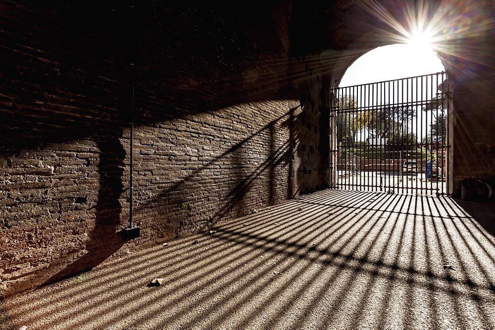 Bars At Entrance Closed And Shadow Cast On The Ground, Rome, Italy