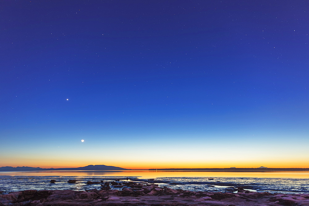 The Moon Rises Above Mount Susitna On A Clear Winter Night, Sea Ice Visible In The Foreground, Anchorage, Alaska, United States Of America