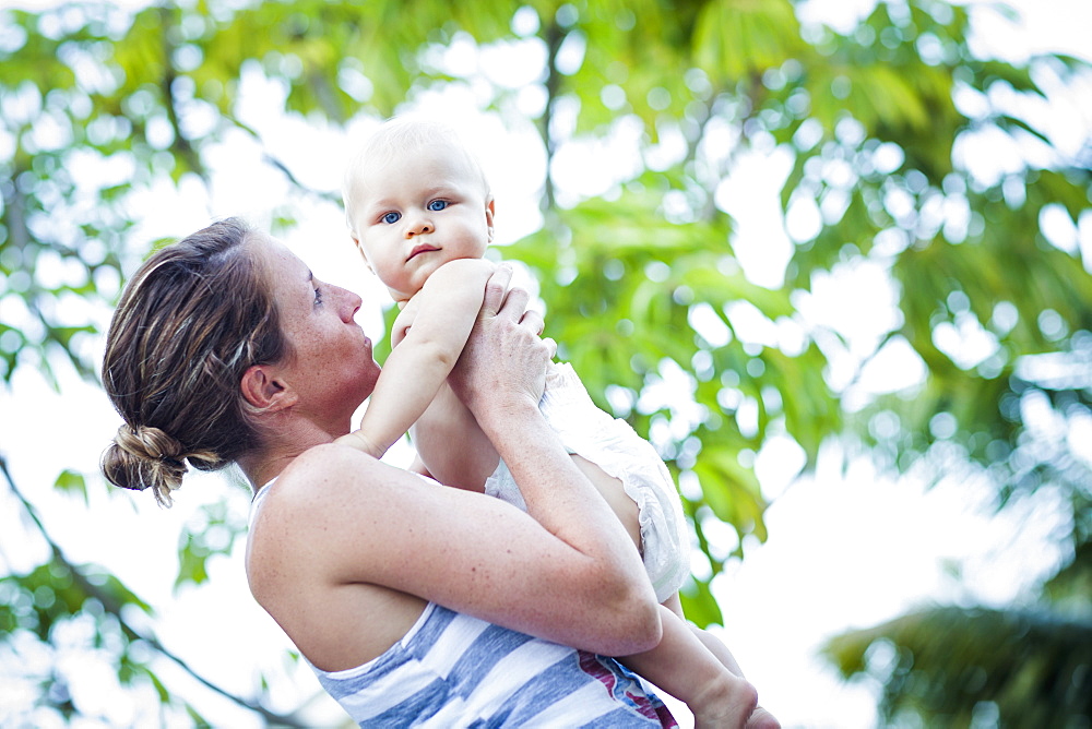 A Mother Holds Her Baby Wearing Only A Diaper On A Warm Day, Fountain Valley, California, United States Of America