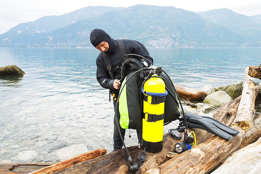 A Scuba Diver Prepares His Equipment Before Making A Dive, Britannia Beach, Howe Sound, British Columbia, Canada