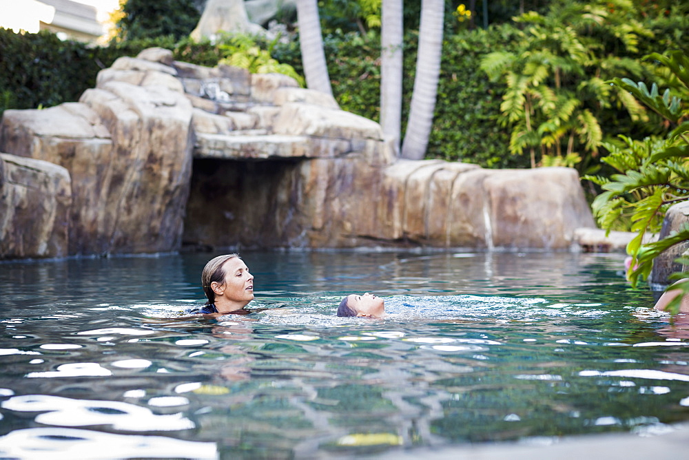 A Family Enjoys An Afternoon In The Pool On A Sunny Afternoon, Fountain Valley, California, United States Of America