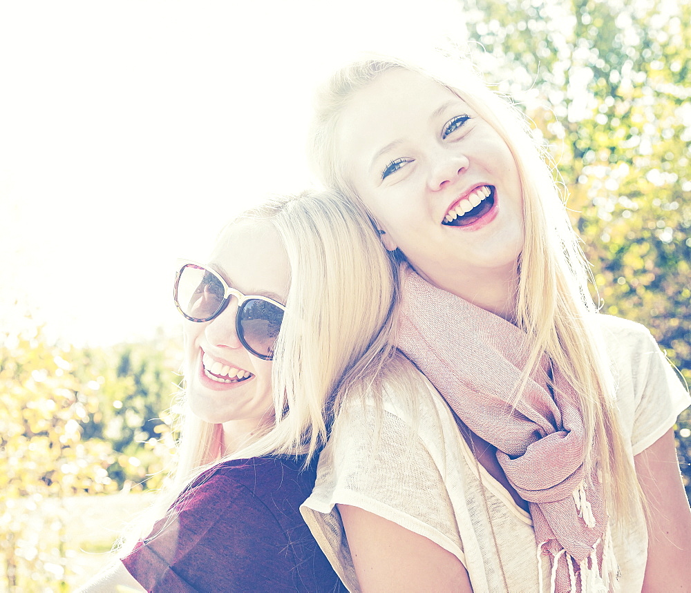 Two Sisters Having Fun Together In A City Park During Autumn And Posing For The Camera, Edmonton, Alberta, Canada