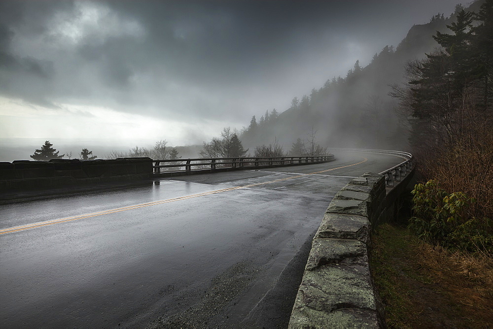 Rain On A Wet Bridge Of North Carolina's Linn Cove Viaduct On The Blue Ridge Parkway With Moody, Low-Hanging Storm Clouds And Mist, North Carolina, United States Of America