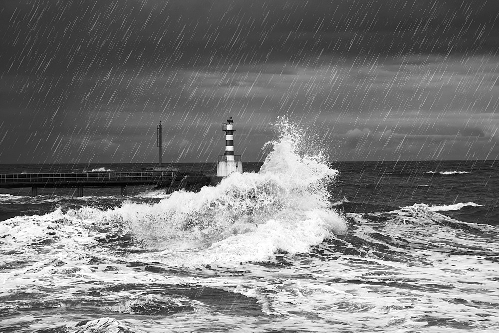 Rainfall And Splashing Waves With A Lighthouse Along The Coast, Amble, Northumberland, England