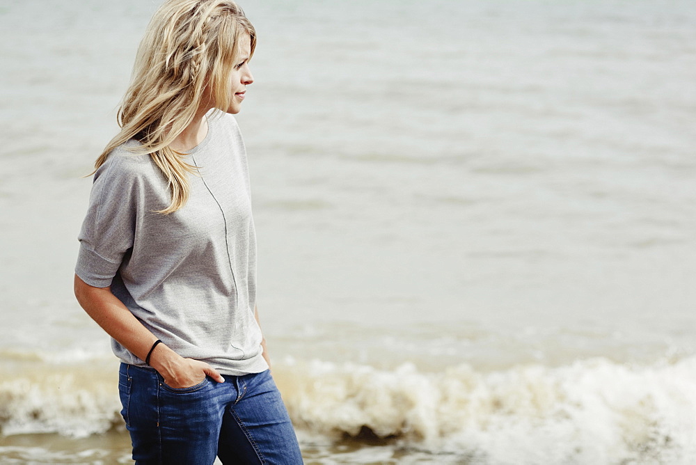 Portrait Of A Young Woman With Long Blond Hair At The Ocean, Hastings, Sussex, England