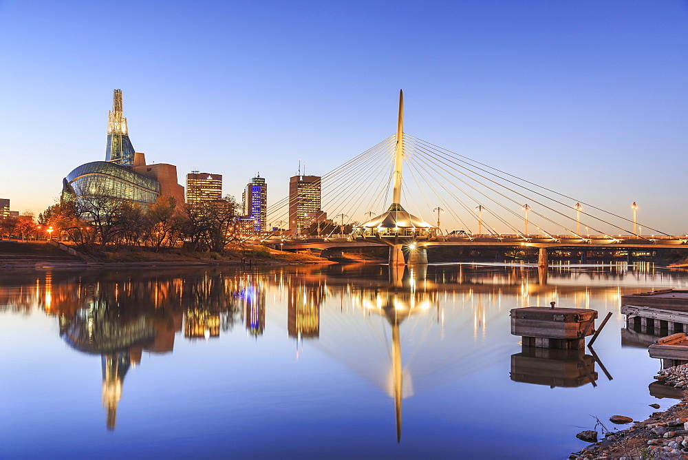 Skyline Of Winnipeg At Night, With Canadian Museum For Human Rights And Esplanade Riel Bridge Reflected In The Red River, Winnipeg, Manitoba, Canada