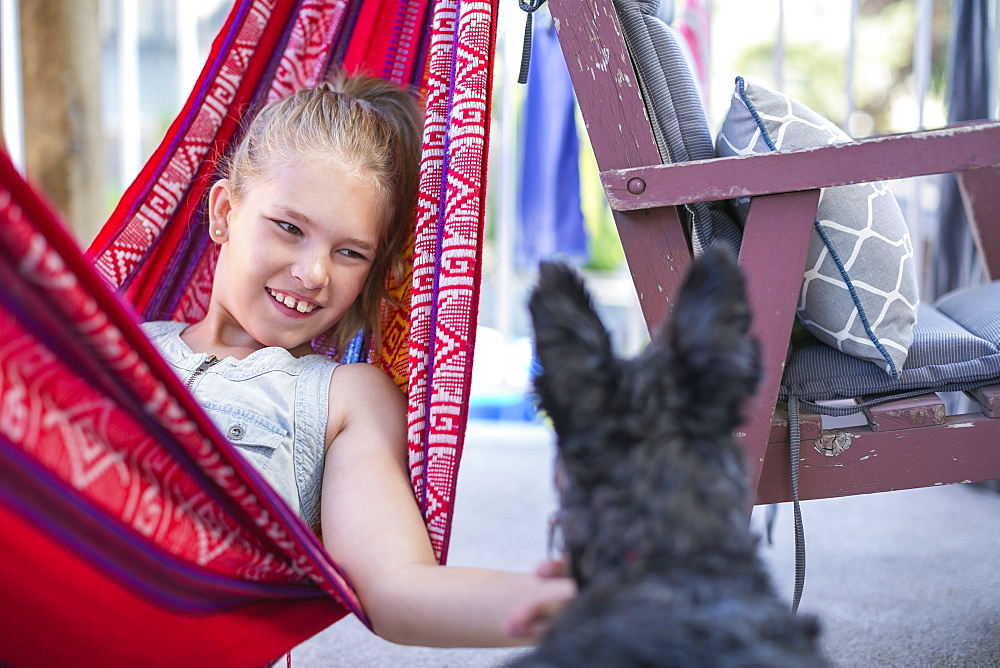 Girl Relaxing In A Hammock And Petting Her Dog, Langley, British Columbia, Canada