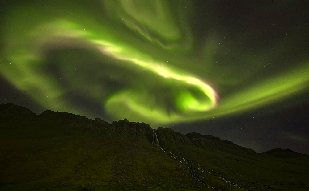 Aurora Overtop Of An Unnamed Waterfall Near The Town Of Djupavik, West Fjords, Iceland