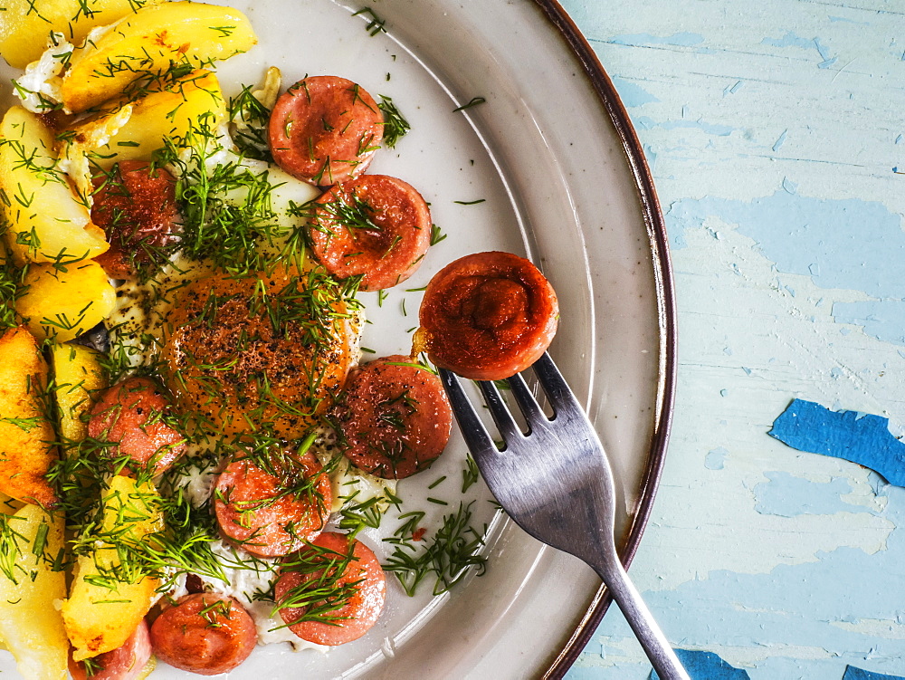 Fried Eggs With Fried Potatoes And Sausages On Plate On Old Weathered Painted Table, Kiev, Ukraine