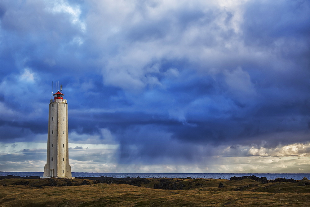 Lighthouse Known As Malarrif On The Snaefellsness Peninsula With Rain Squall Falling In The Background, Iceland