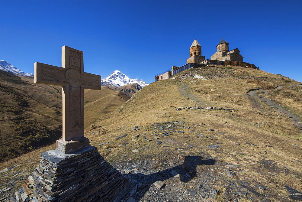 Stone Cross And Gergeti Trinity Church With Mount Kazbek In The Background, Kazbegi, Mtskheta-Mtianeti, Georgia