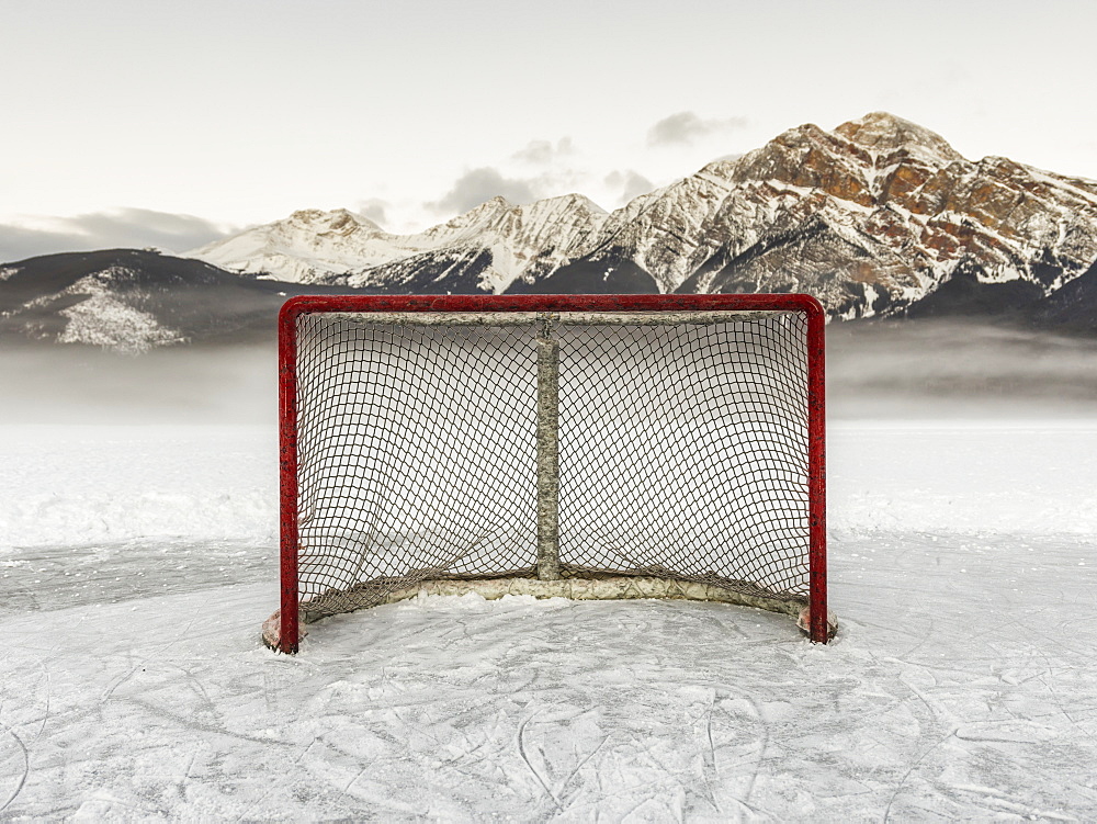 A Hockey Net On Frozen Pyramid Lake With The Rugged Canadian Rockies Mountain Range In The Background, Jasper National Park, Alberta, Canada