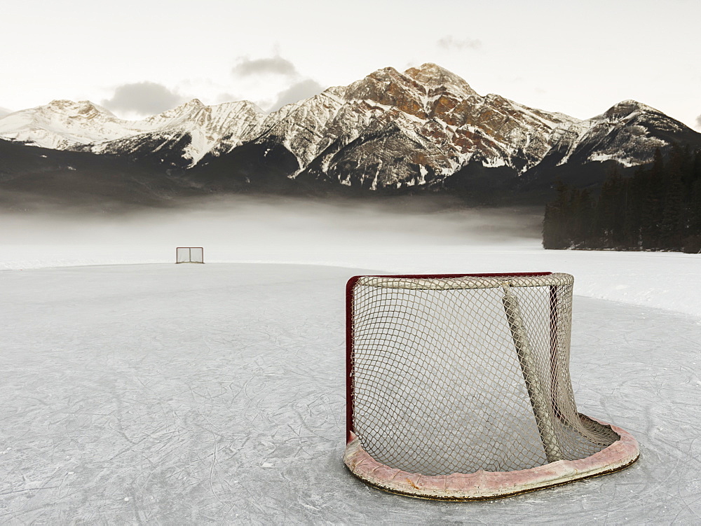 A Hockey Net On Frozen Pyramid Lake With The Rugged Canadian Rockies Mountain Range In The Background, Jasper National Park, Alberta, Canada