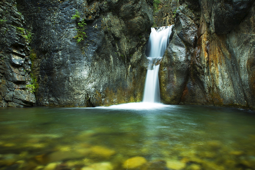 A Double Waterfall Drops Into Green Water In A Dark Canyon, Kananaskis Country, Alberta, Canada