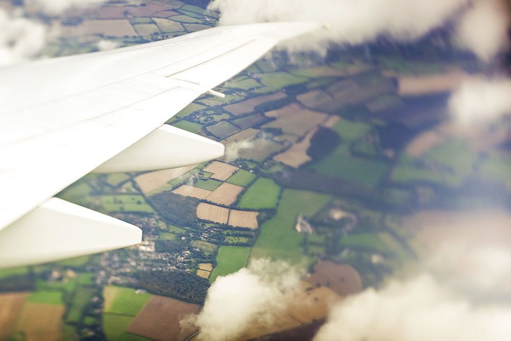 Aerial view of a patchwork landscape of farmland out the window of an airplane, Hastings, England