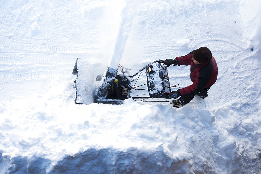 Directly Above A Man Using A Snowblower, Homer, Alaska, United States Of America