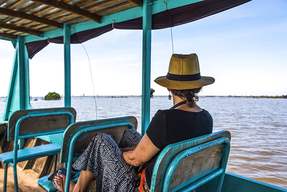 A Woman Sits On A Boat Looking Out At The Water As It Tours Down A River, Siem Reap Province, Cambodia