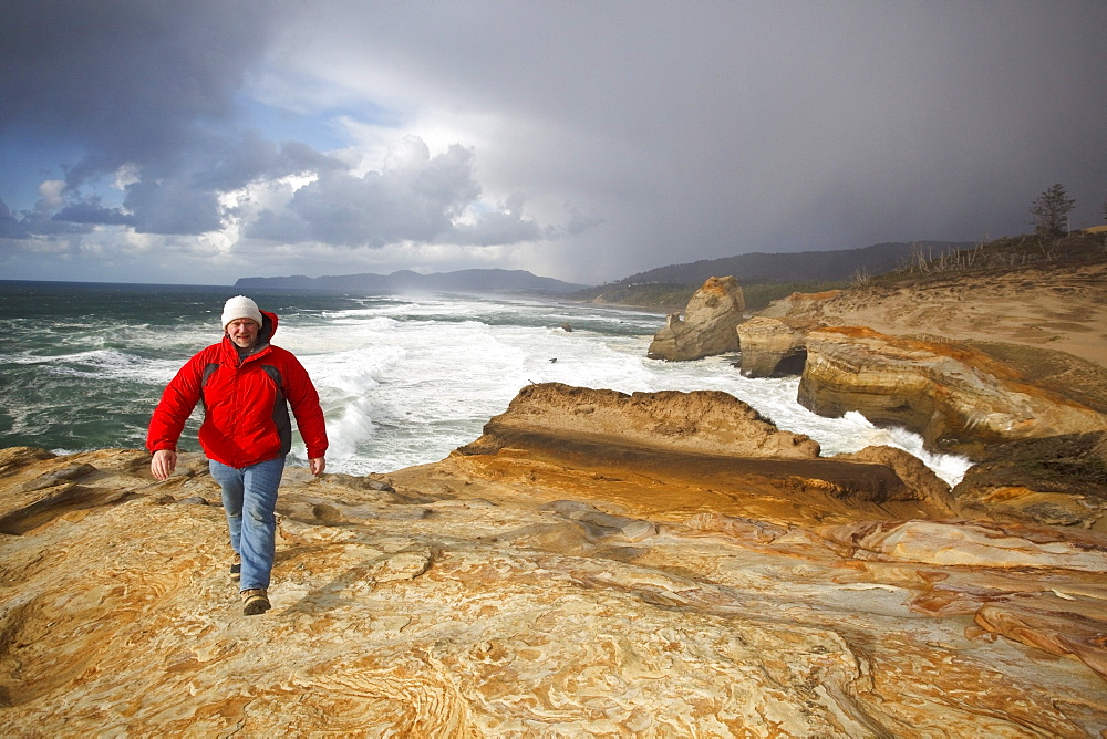 Pacific City, Oregon, United States Of America; A Man Walking Along The Coast At Cape Kiwanda