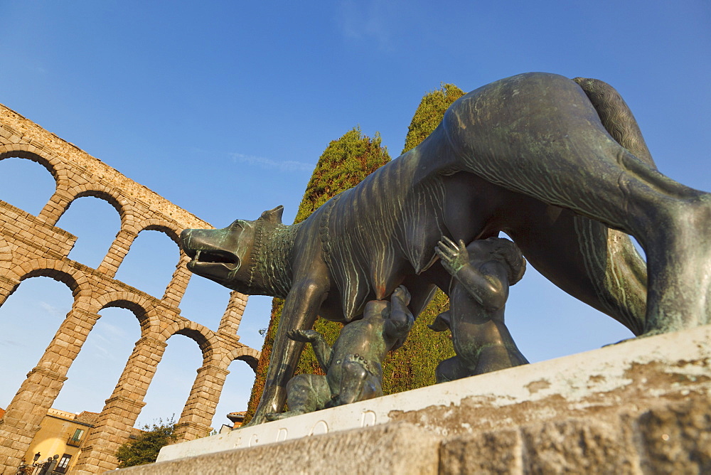 Statue Of A She-Wolf Suckling Romulus And Remus With The Roman Aqueduct In The Background; Segovia, Segovia Province, Spain