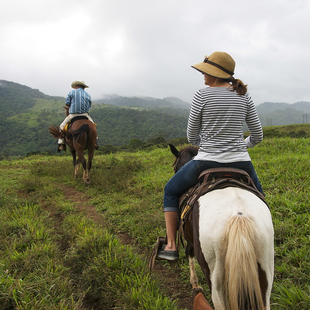 A Man And Woman Riding Horseback Through The Hills, Zacapa, Guatemala