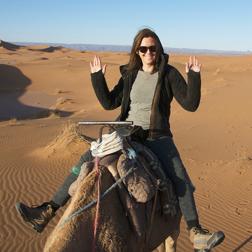 A woman riding a camel with no hands being silly, Souss-massa-draa morocco