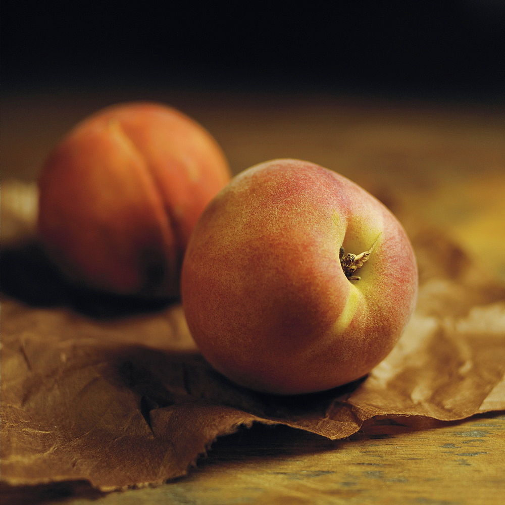 Peaches Sitting On Brown Parchment Paper On A Wooden Counter, Toronto, Ontario, Canada