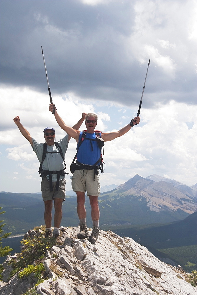 Two Men Cheering At The Top Of A Mountain