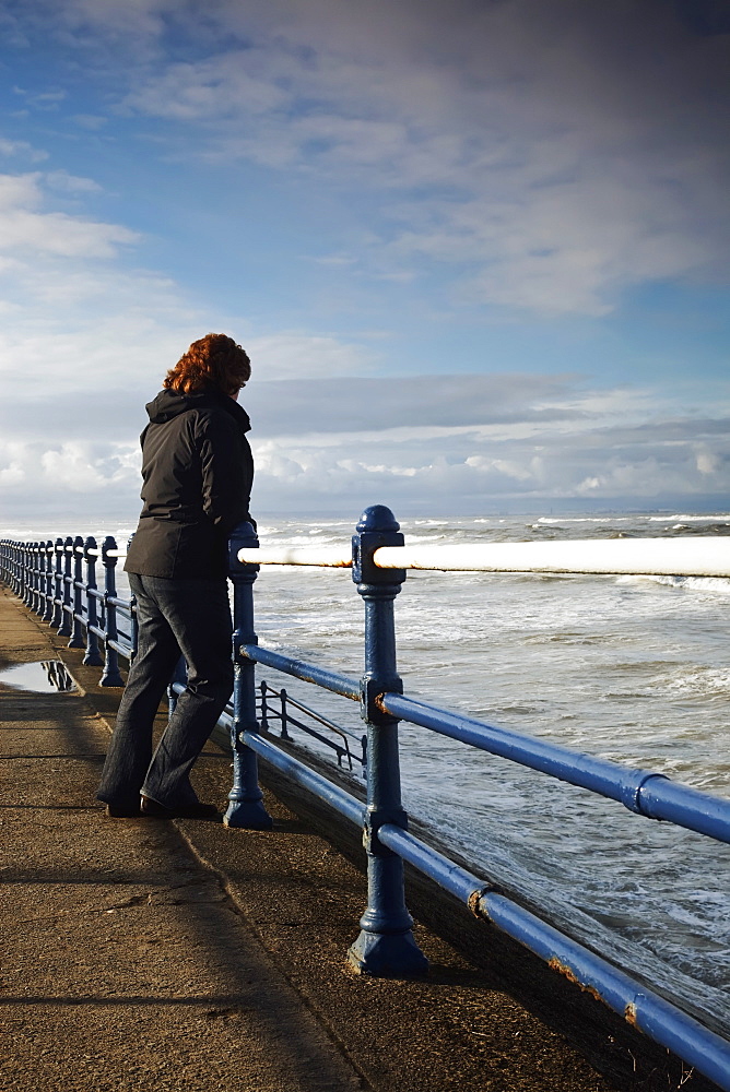 Saltburn, Teesside, England, A Woman Standing At A Railing And Looking Out Over The Ocean