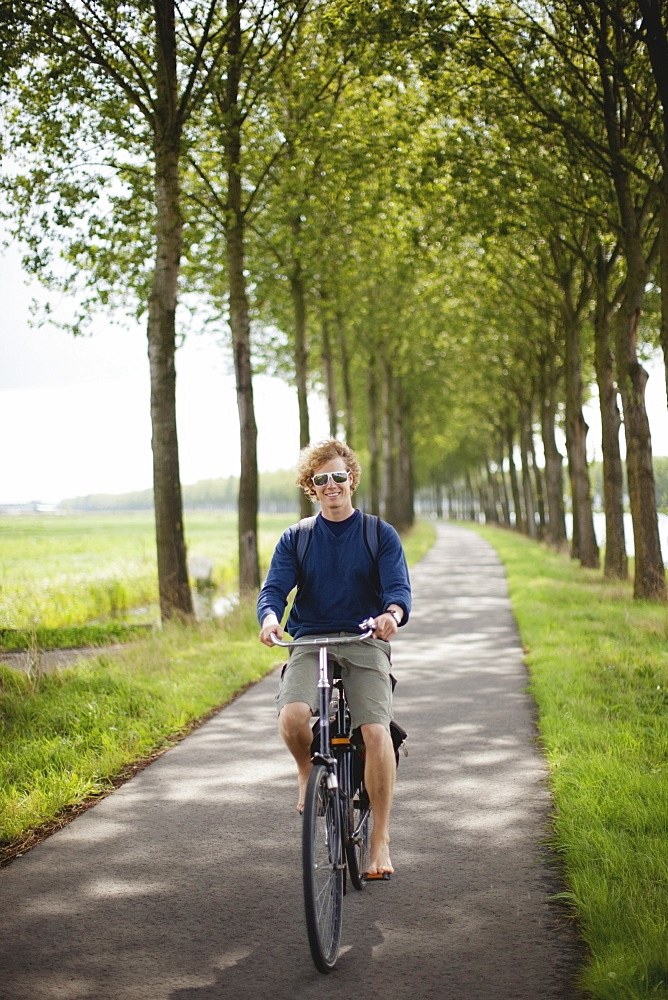 A Boy Riding His Bike Along The Dutch Canals, Houten, The Netherlands