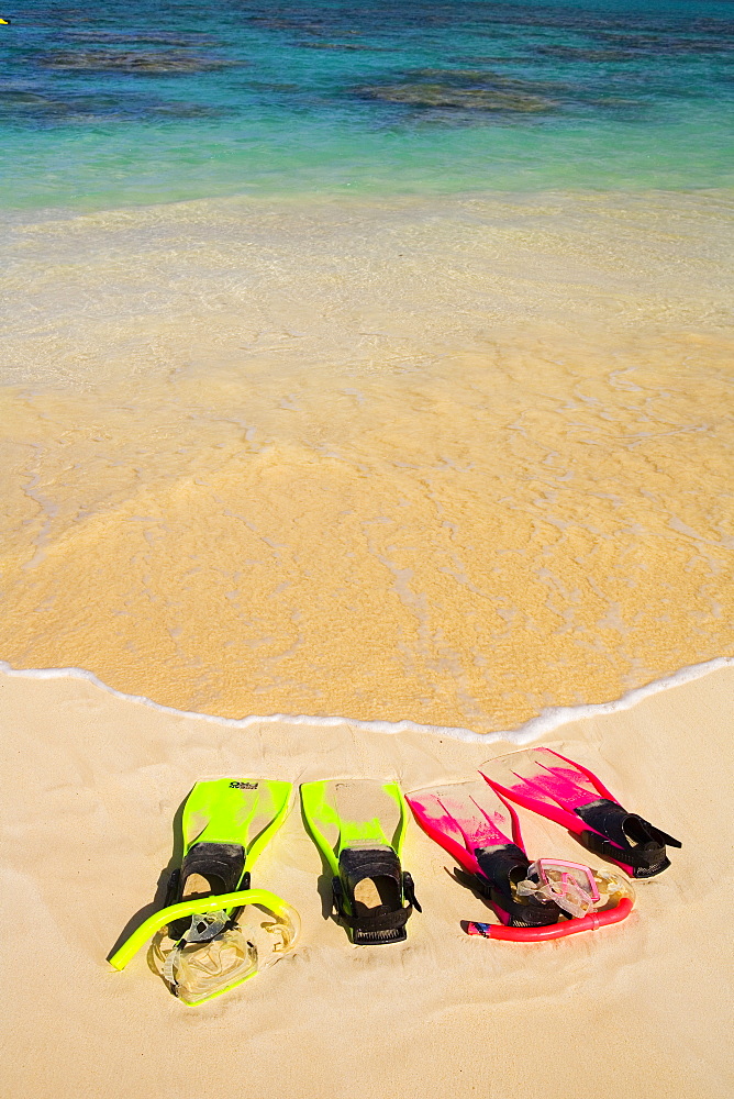 Two Sandy Snorkel Sets Rest At The Waters Edge On A Tropical Beach.