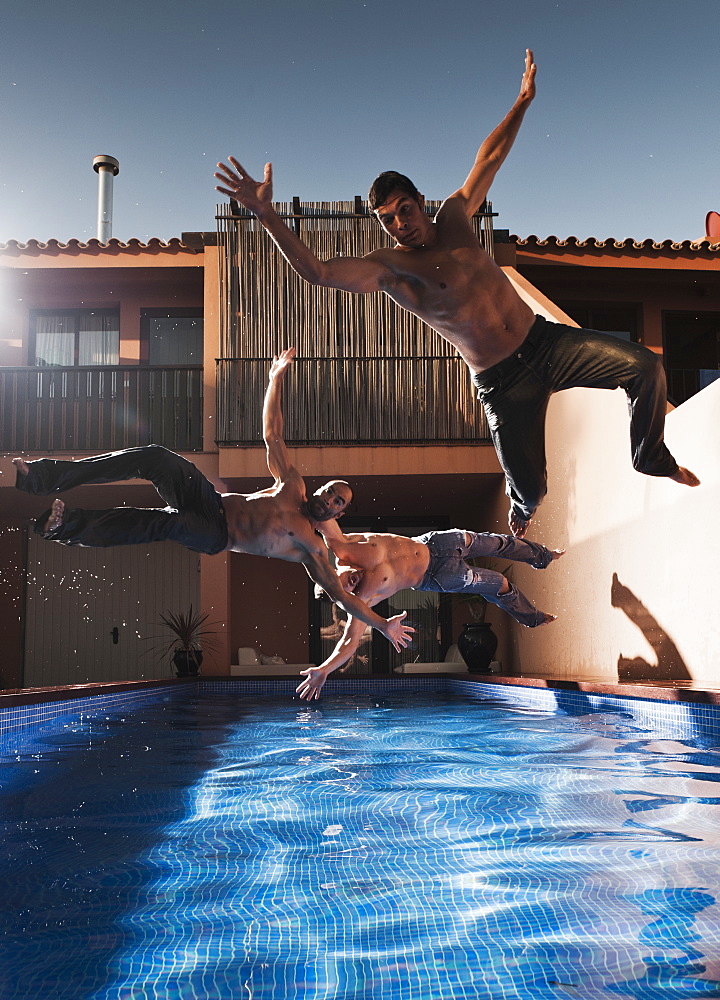 Three Men Jumping Into A Pool Wearing Their Pants, Tarifa, Cadiz, Andalusia, Spain