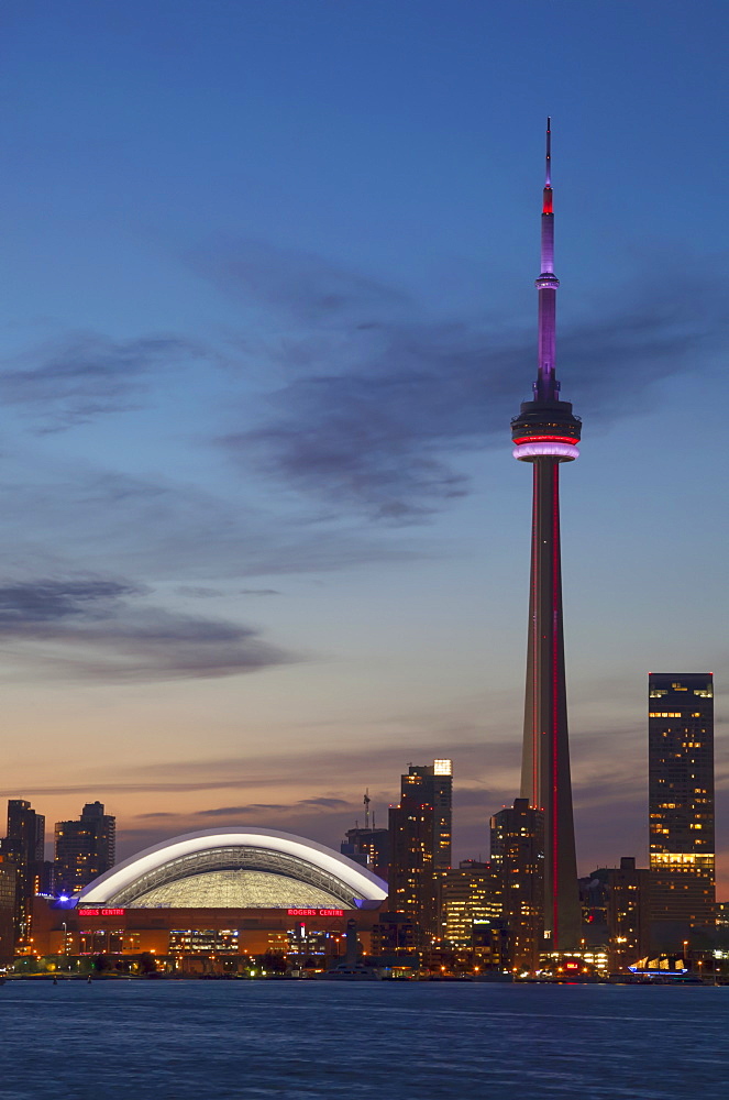 View over lake ontario of the downtown toronto skyline and cn tower illuminated at dusk, Toronto ontario canada