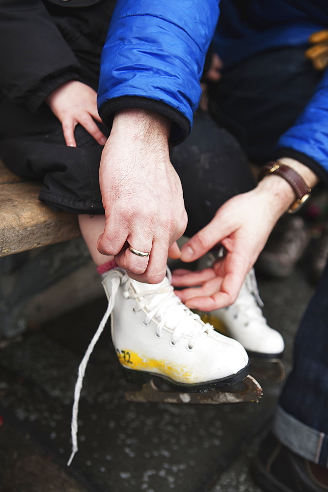 A Father Ties His Child's Ice Skates, Toronto, Ontario, Canada