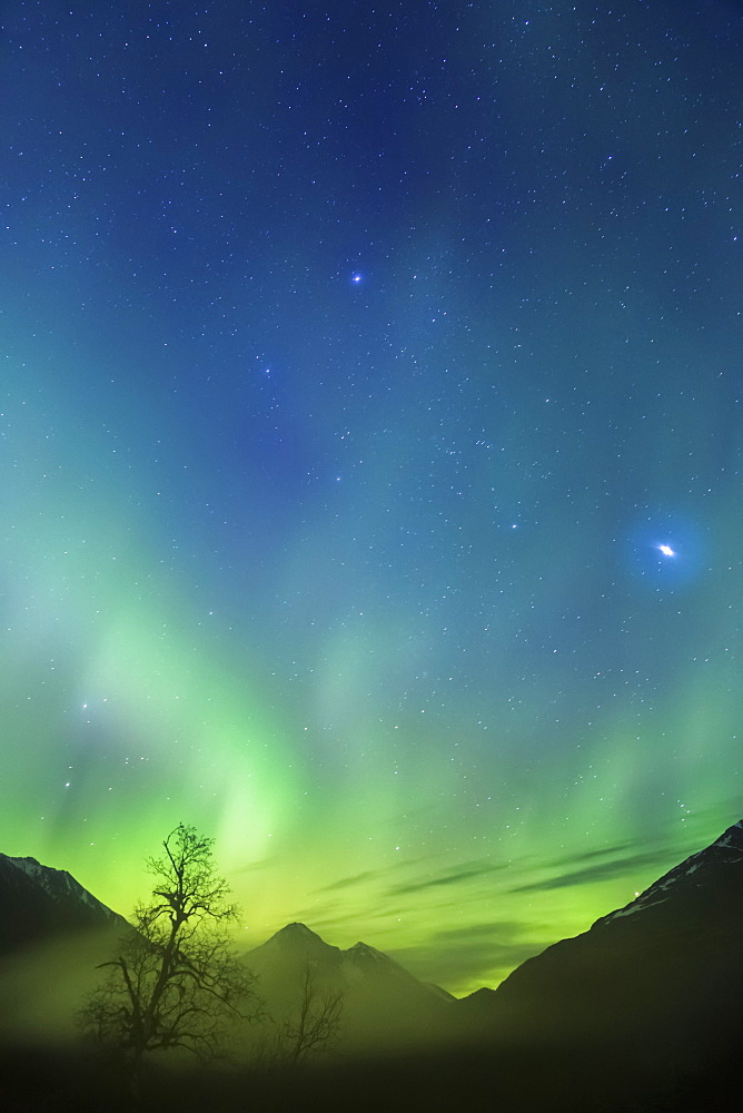 Northern Lights In The Sky Above Moose Pass, With Silhouetted Kenai Mountains In The Fog And Low Cloud, Chugach National Forest, Moose Pass, Alaska, United States Of America