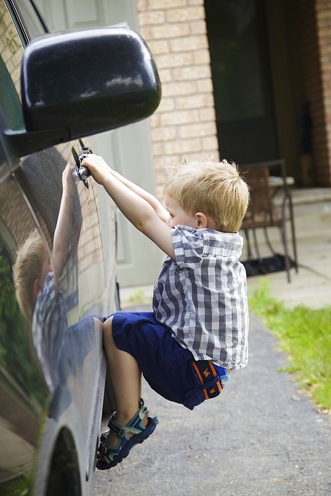 A Young Boy Playing On A Car, Guelph, Ontario, Canada