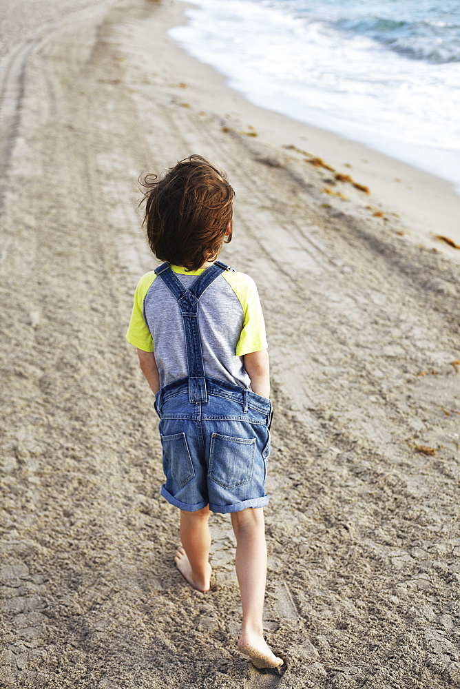 Young Boy Walking On The Beach, Hollywood, Florida, United States Of America