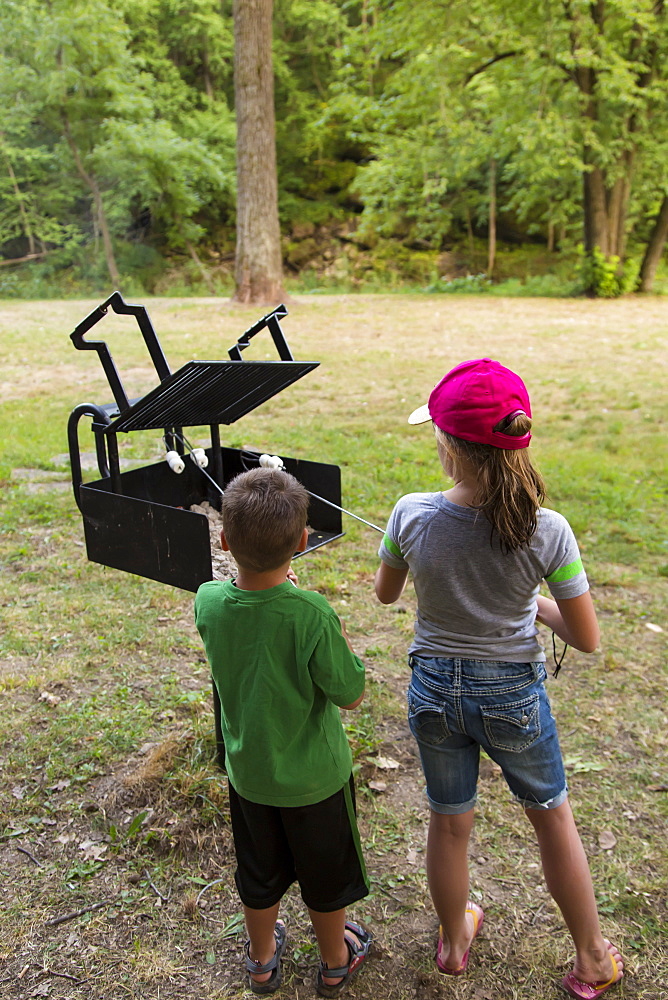 Two Kids Roasting Marshmallows At Bixby State Preserve, Near Edgewood, Iowa, United States Of America