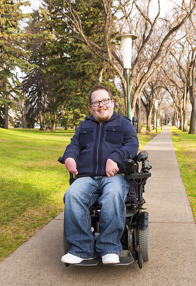 Disabled Man Using His Powered Wheelchair In A Park In Autumn, Edmonton, Alberta, Canada