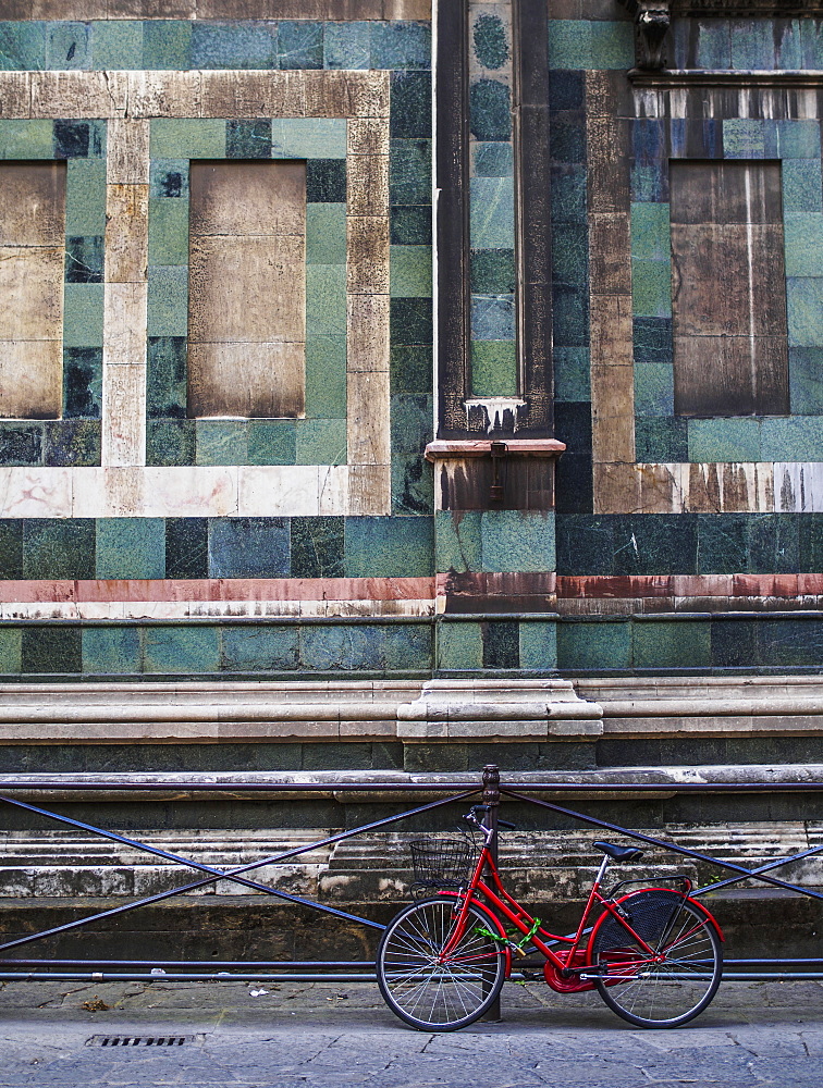 A Red Bike Contrasted With The Green Granite Of The Building Behind It, Florence, Italy