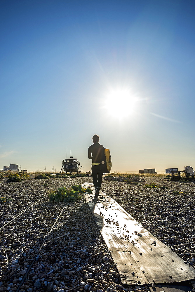 Girl Walking On Dungeness Shingle Beach, Dungeness, Kent, England