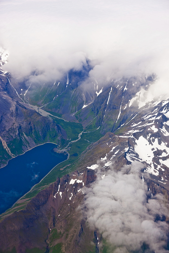 Aerial View Of Clouds Obscuring Peaks With A Lush Green Valley And Lake Visible In The Foreground, Aleutian Range, Alaska Peninsula, Southwestern Alaska, USA, Summer