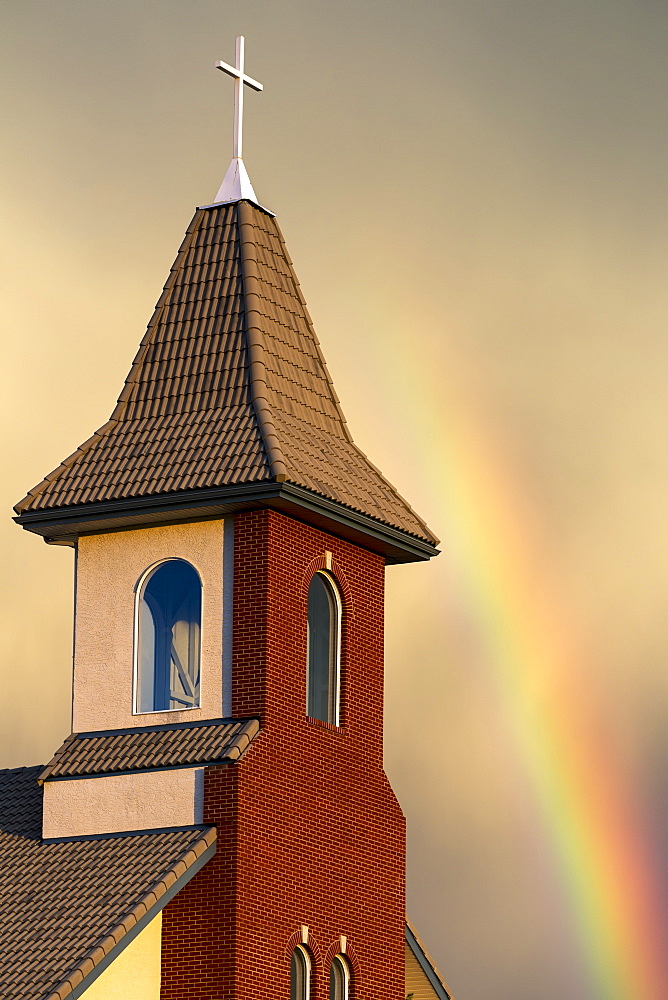 Church Steeple With Orange Glow From The Sunset And Rainbow In The Sky, Calgary, Alberta, Canada