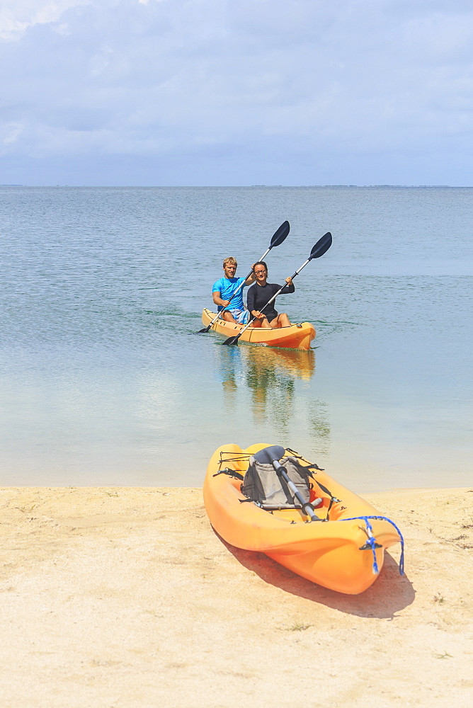 A Couple Arriving At The Beach In A Kayak, Saint Georges Caye Resort, Belize City, Belize