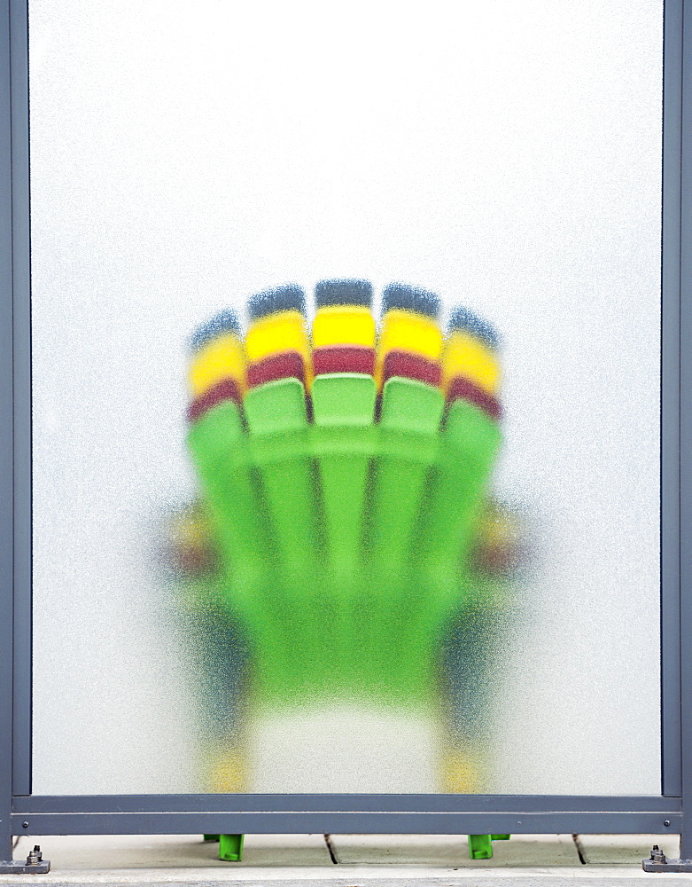 Four Colourful Deck Chairs Stacked And Leaning Against Frosted Glass, Toronto, Ontario, Canada