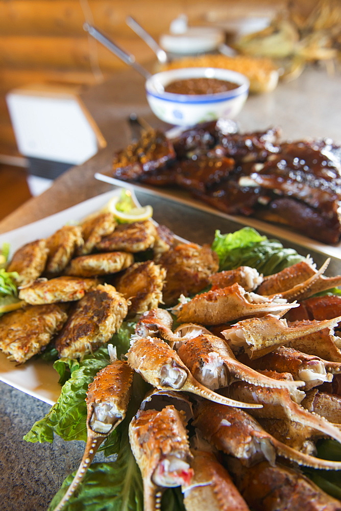 A Spread Of Crab Claws, Crab Cakes And Barbecue Ribs Awaits Guests At The Katmai Wilderness Lodge In Kukak Bay, Katmai National Park & Preserve, Alaska.